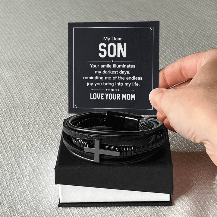 To My Dear Son | Your smile illuminates' my darkest shades - Men's Cross Leather Bracelet